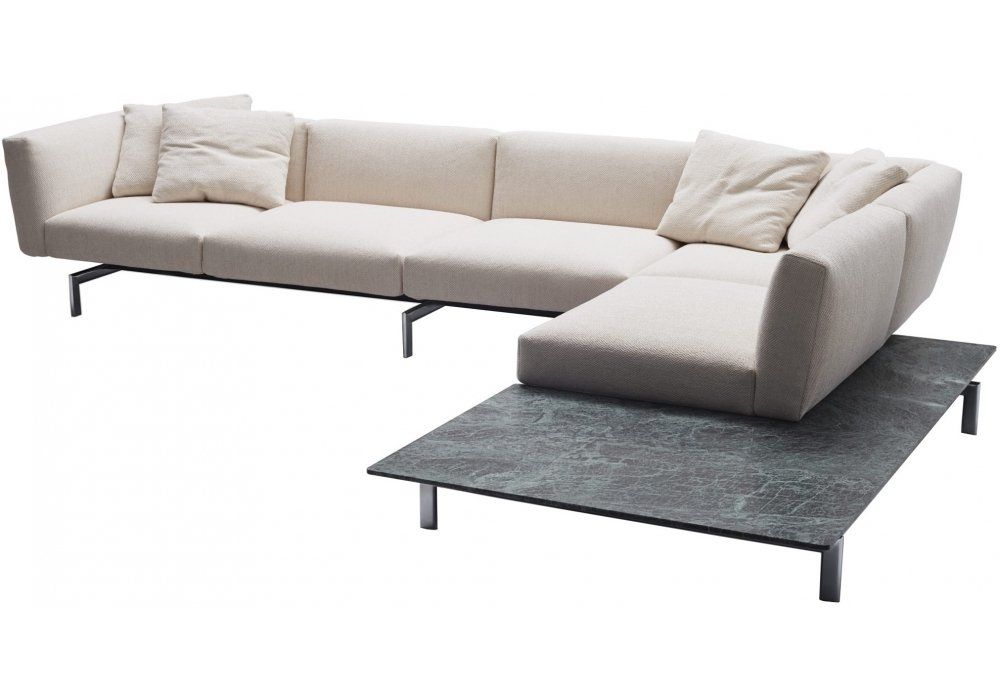 Eine weiße Sofagarnitur mit einem schwarzen Tisch darunter