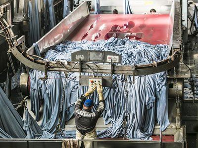 Ein Mann arbeitet in einer Fabrik an einer Maschine.