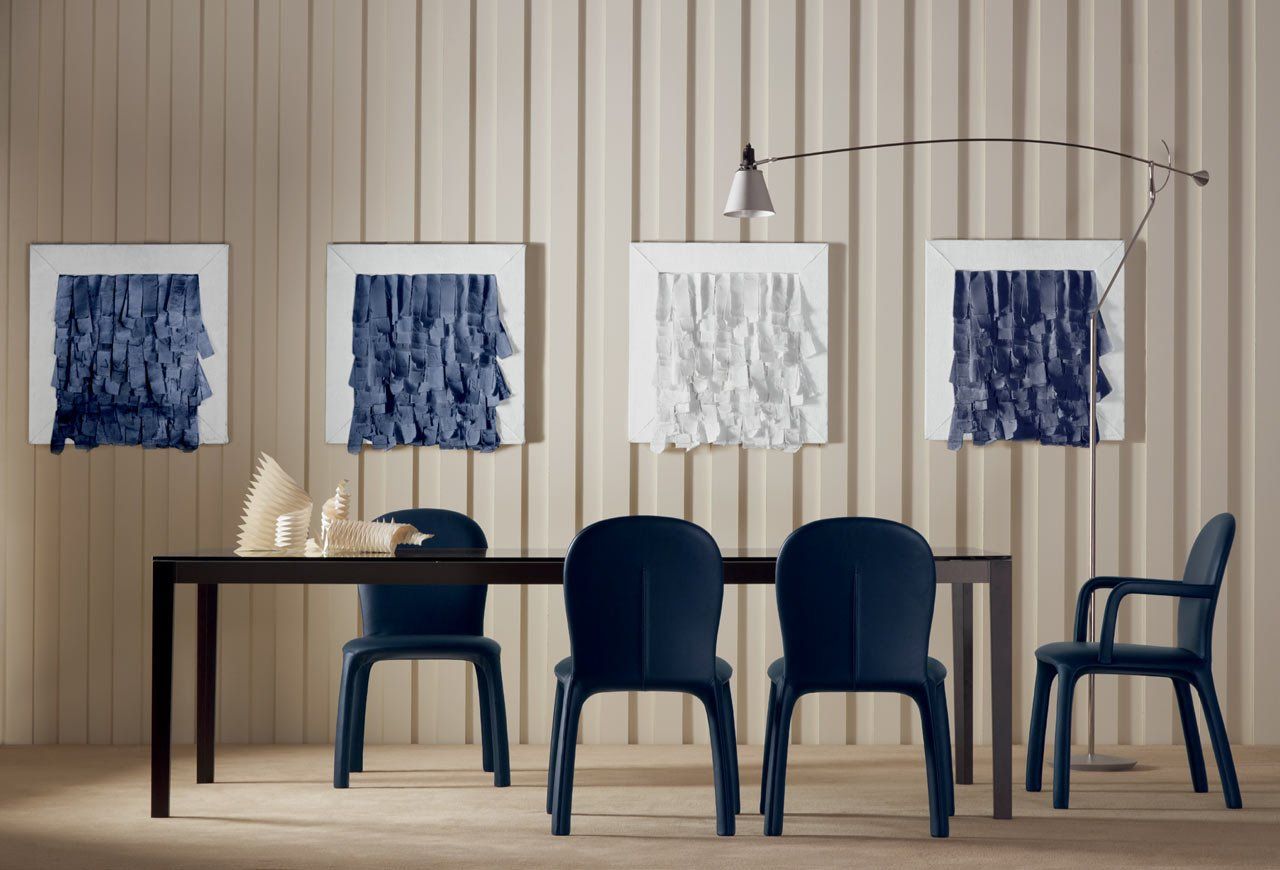 Ein Esszimmer mit Tisch und Stühlen und Gemälden an der Wand