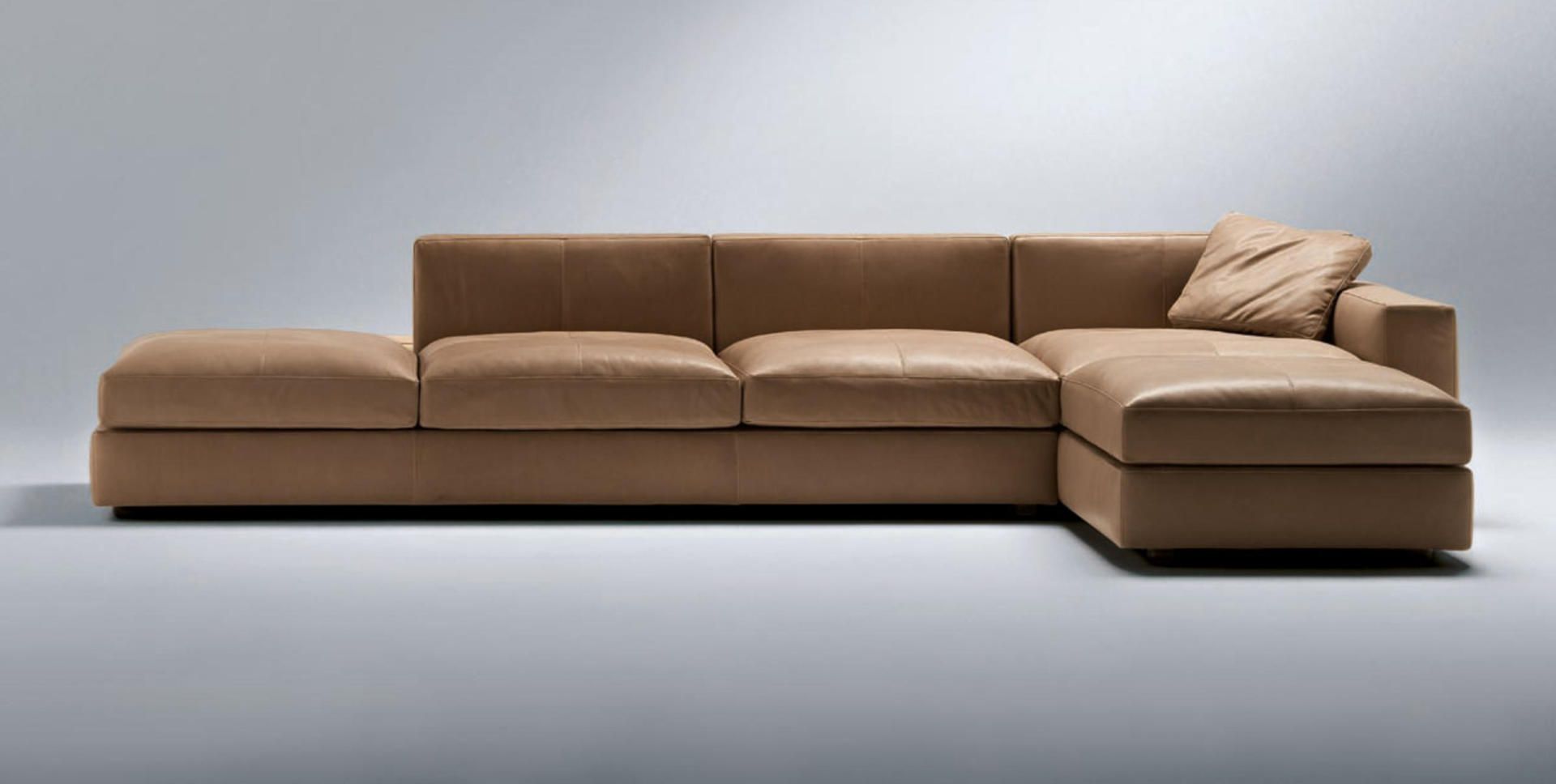 Eine braune Ledercouch mit Kissen darauf