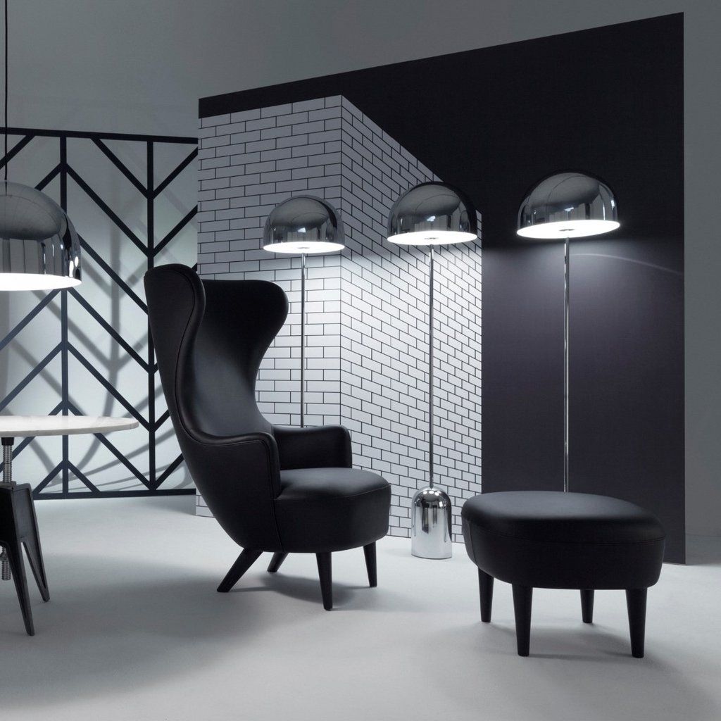 Ein schwarz-weißes Zimmer mit einem Stuhl und Ottomane