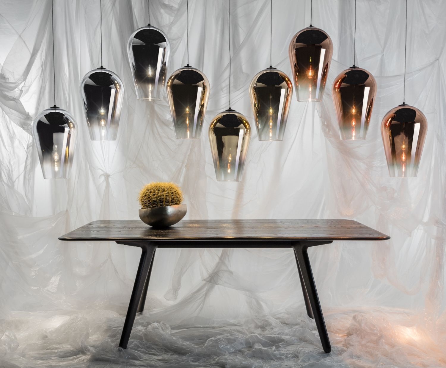 Ein Tisch mit einer Pflanze darauf vor einem Vorhang