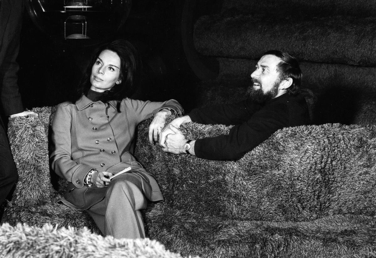 Auf einem Schwarzweißfoto sitzen ein Mann und eine Frau auf einer Couch.