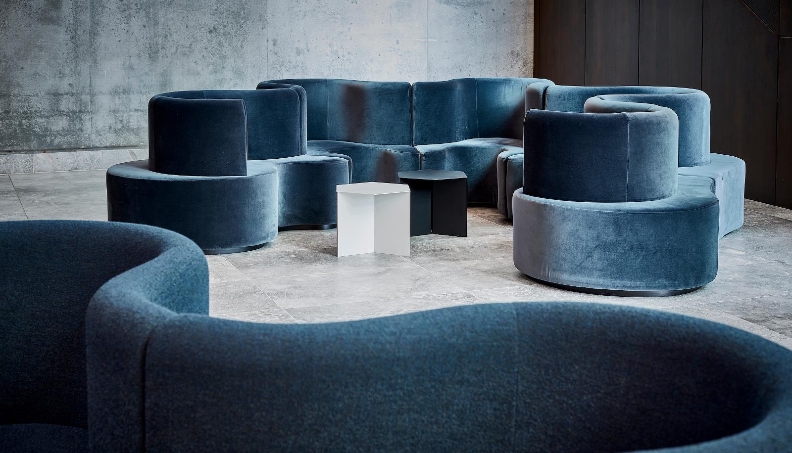 Ein Raum mit vielen blauen Stühlen und Tischen