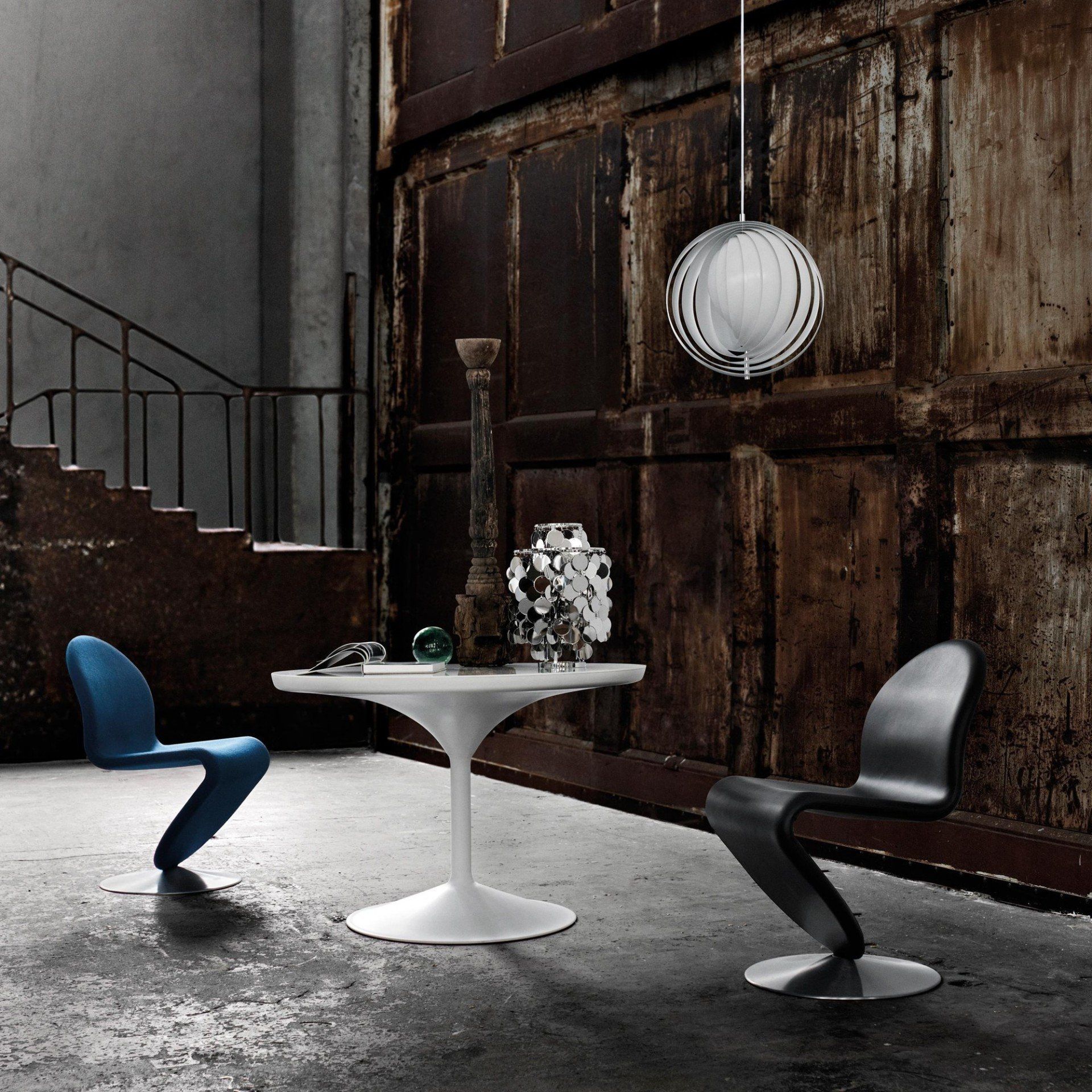 Ein Raum mit einem Tisch und Stühlen vor einer Holzwand