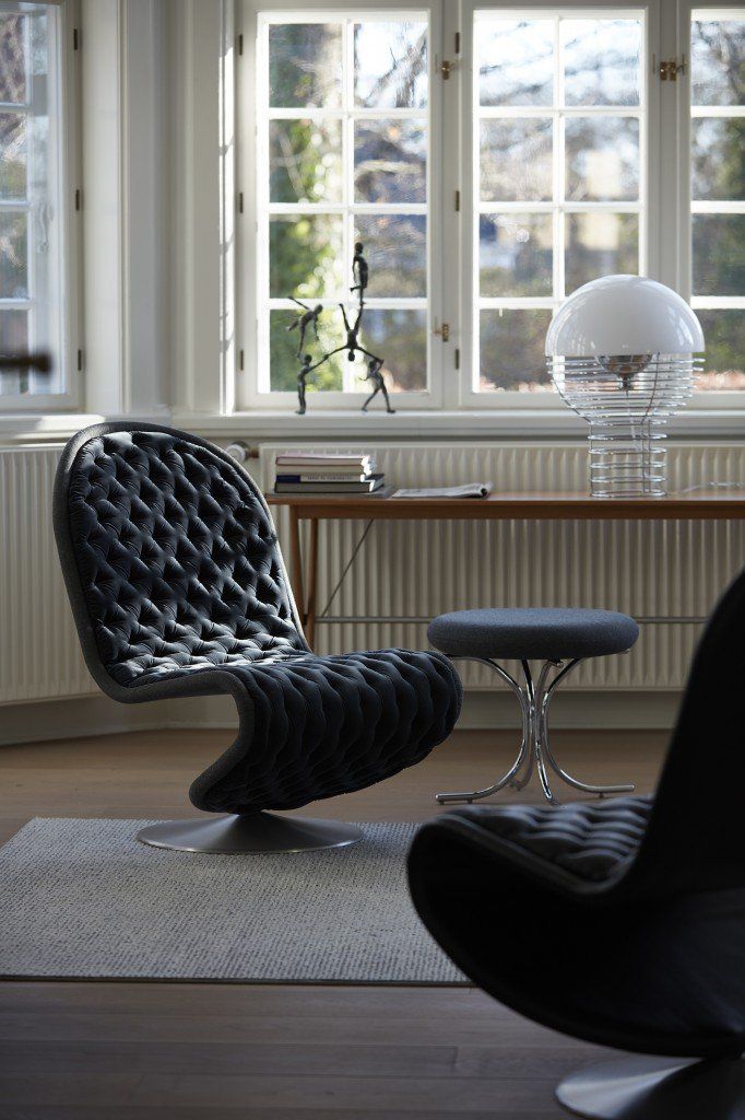 Ein Wohnzimmer mit einem Sessel und einem Ottoman vor einem Fenster