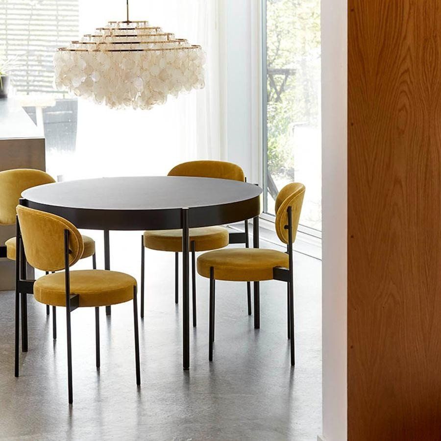 Ein Esszimmer mit einem runden Tisch und gelben Stühlen