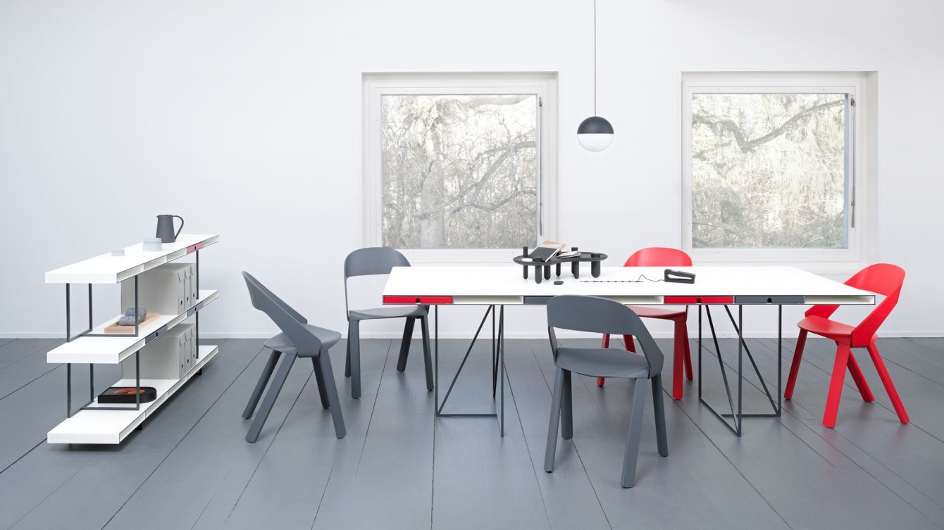 Ein Raum mit einem Tisch und Stühlen und einem Bücherregal