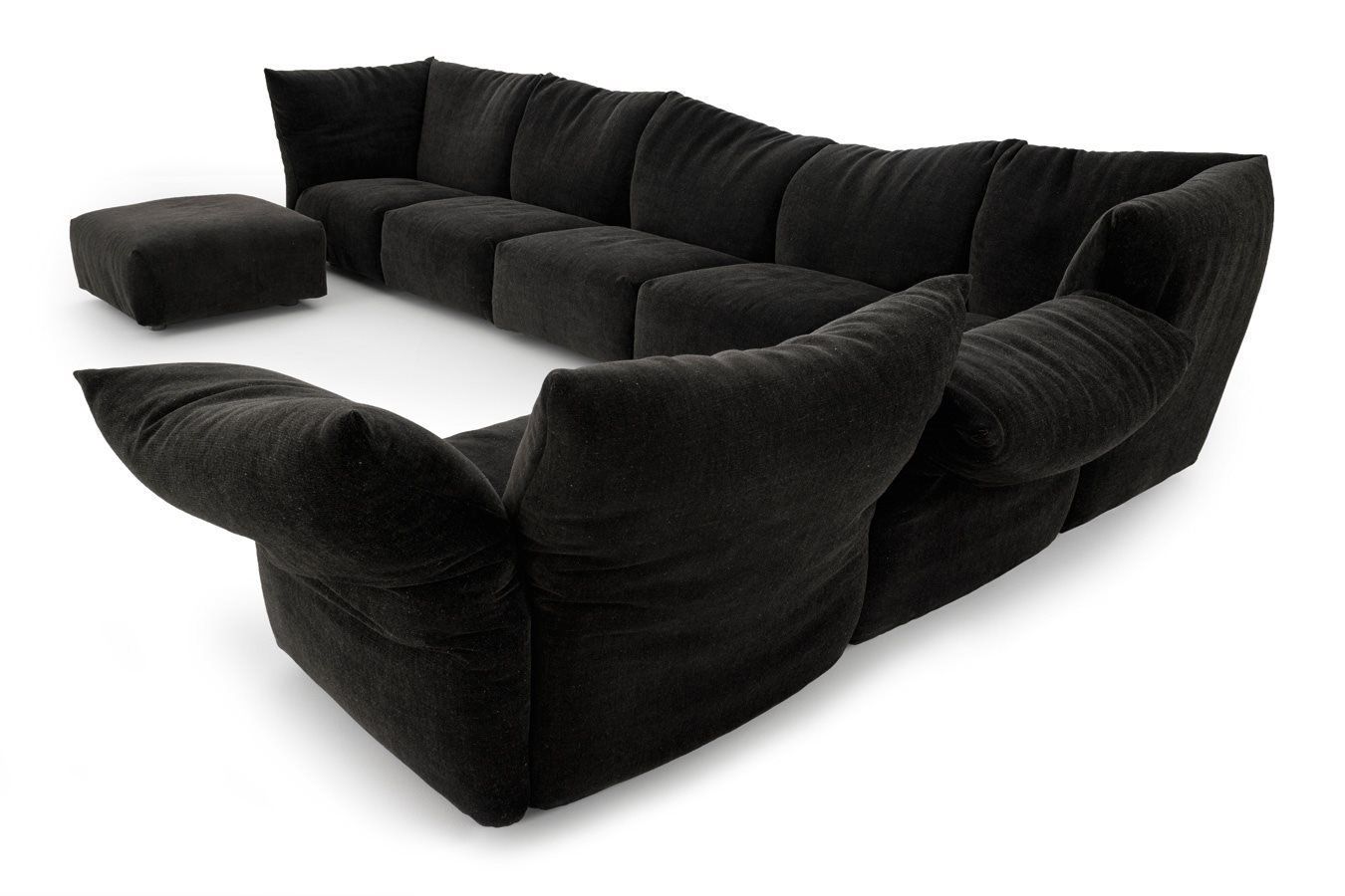 Eine schwarze Sofagarnitur und Ottomane auf weißem Hintergrund