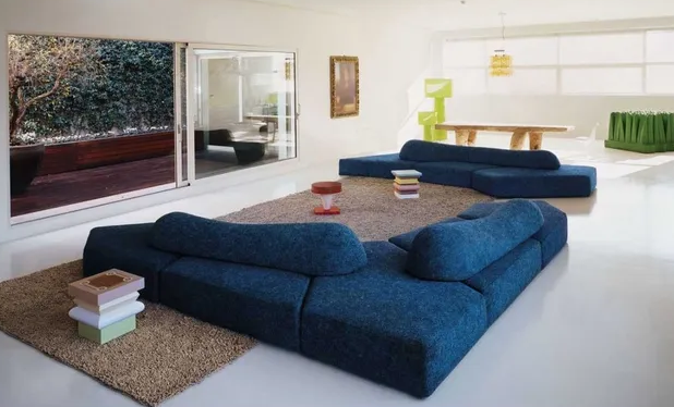 Ein Wohnzimmer mit einer blauen Couch und einem Teppich