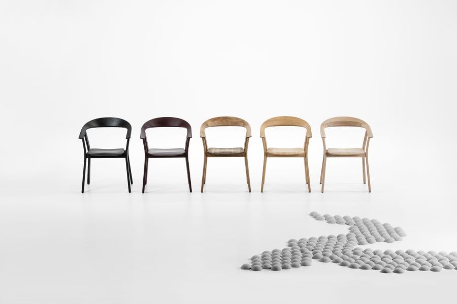 Eine Reihe Stühle in verschiedenen Farben auf weißem Untergrund