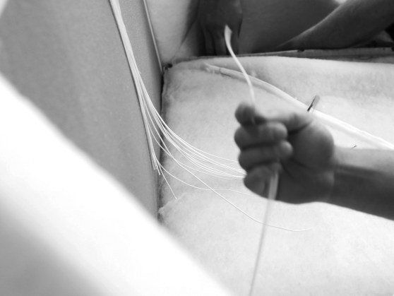 Auf einem Schwarzweißfoto hält eine Person eine Schnur in der Hand.