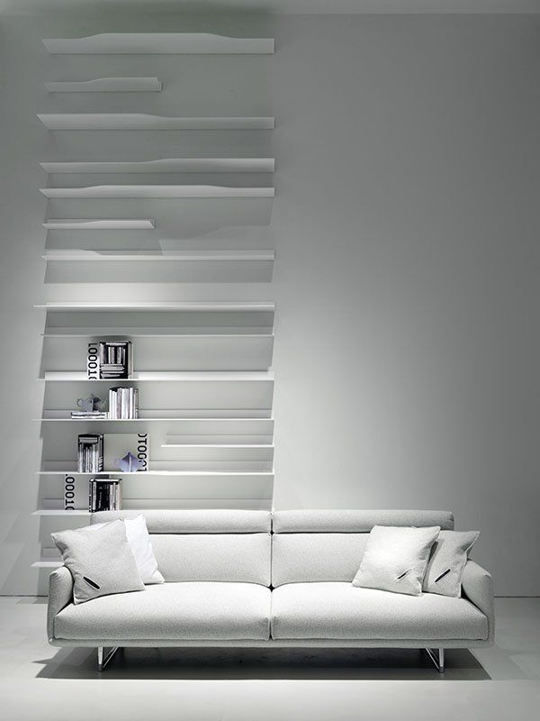 Eine weiße Couch vor einer Wand mit Regalen