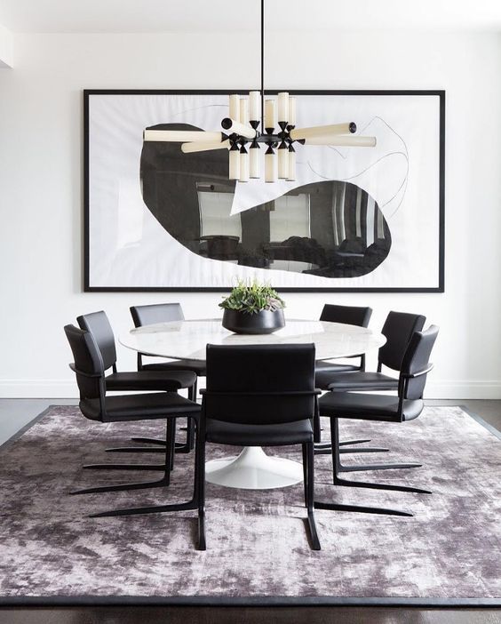 Ein Esszimmer mit Tisch und Stühlen und einem großen Gemälde an der Wand