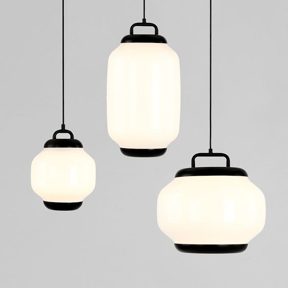 Von der Decke hängen drei Pendelleuchten mit weißen Glasschirmen.