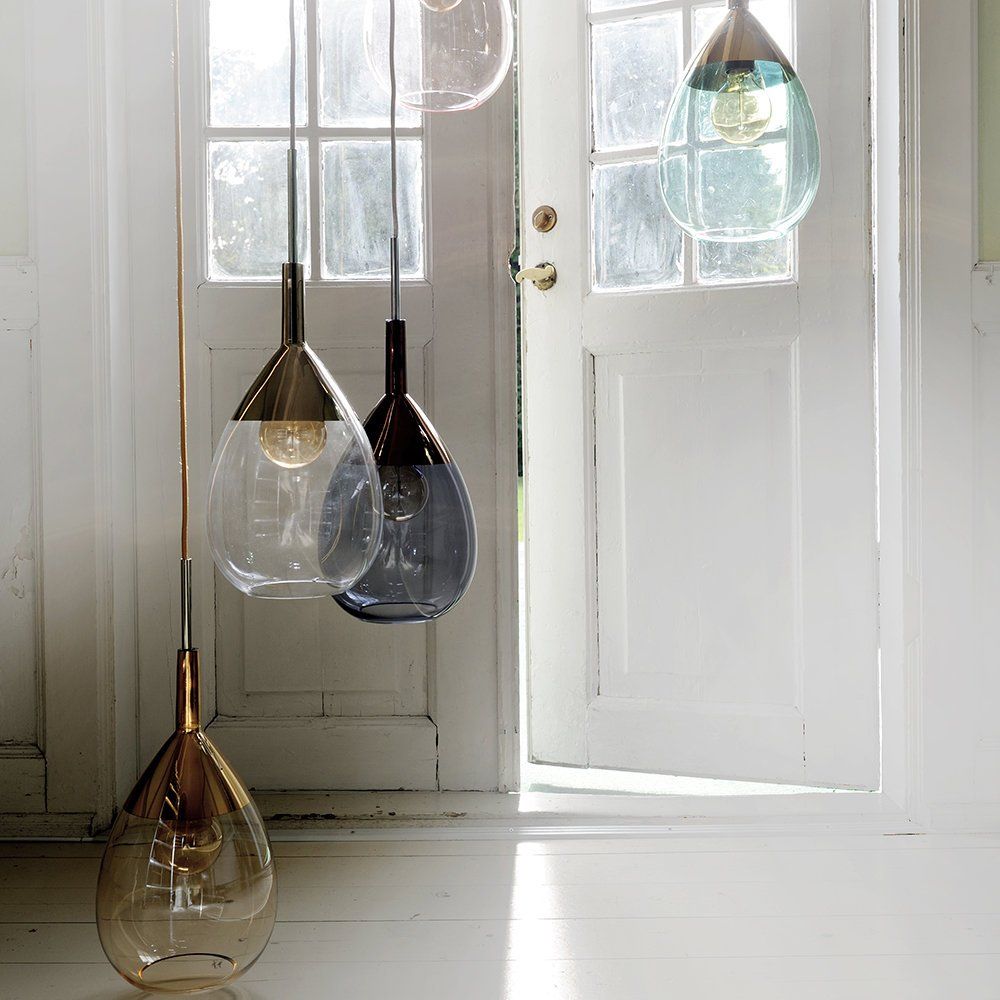 Eine Gruppe von Pendelleuchten, die von der Decke vor einer Tür hängen