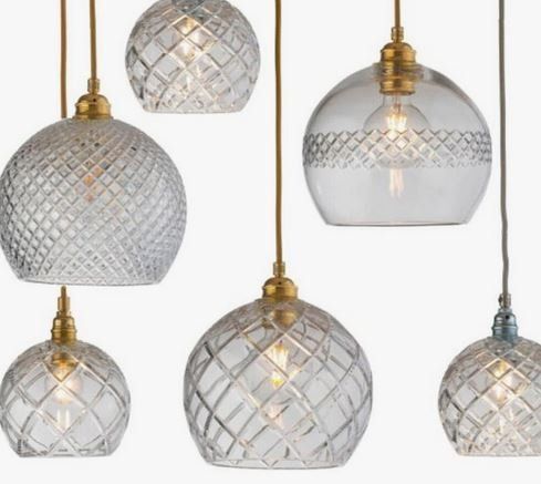 Eine Gruppe von Pendelleuchten mit klaren Glasschirmen