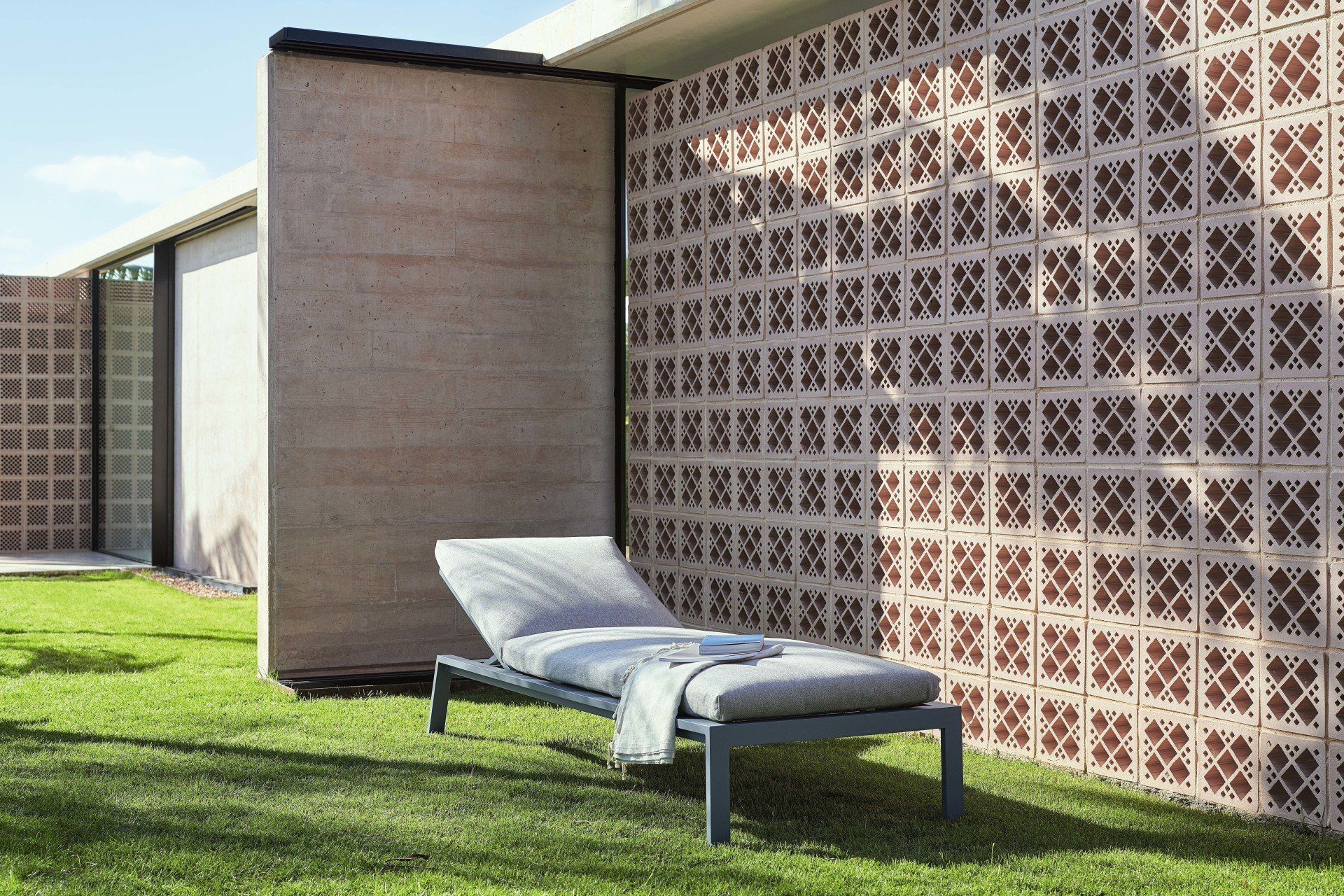 Ein Loungesessel steht vor einer Backsteinmauer