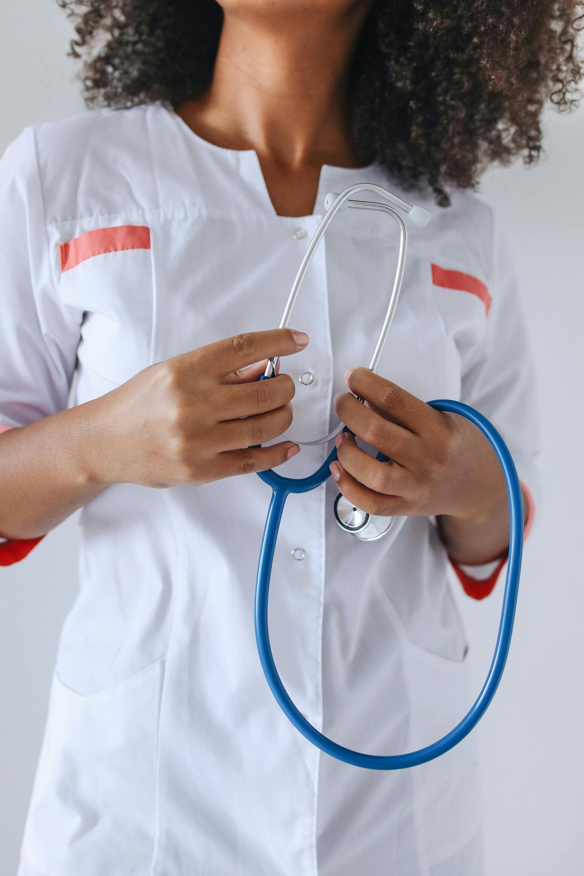 Doctor in white uniform holding a stethoscope.