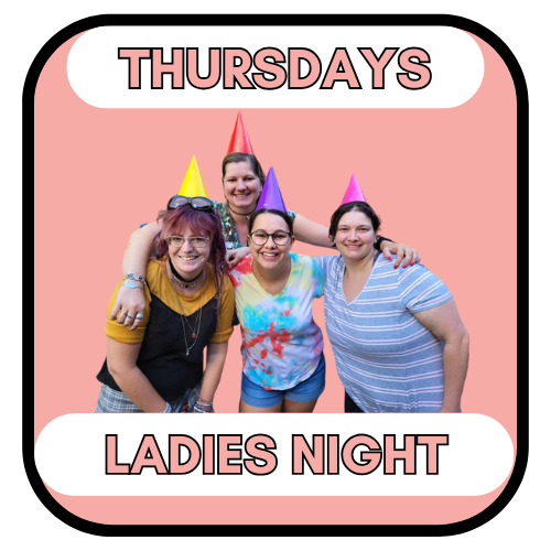 Four women in party hats, hugging, celebrating 