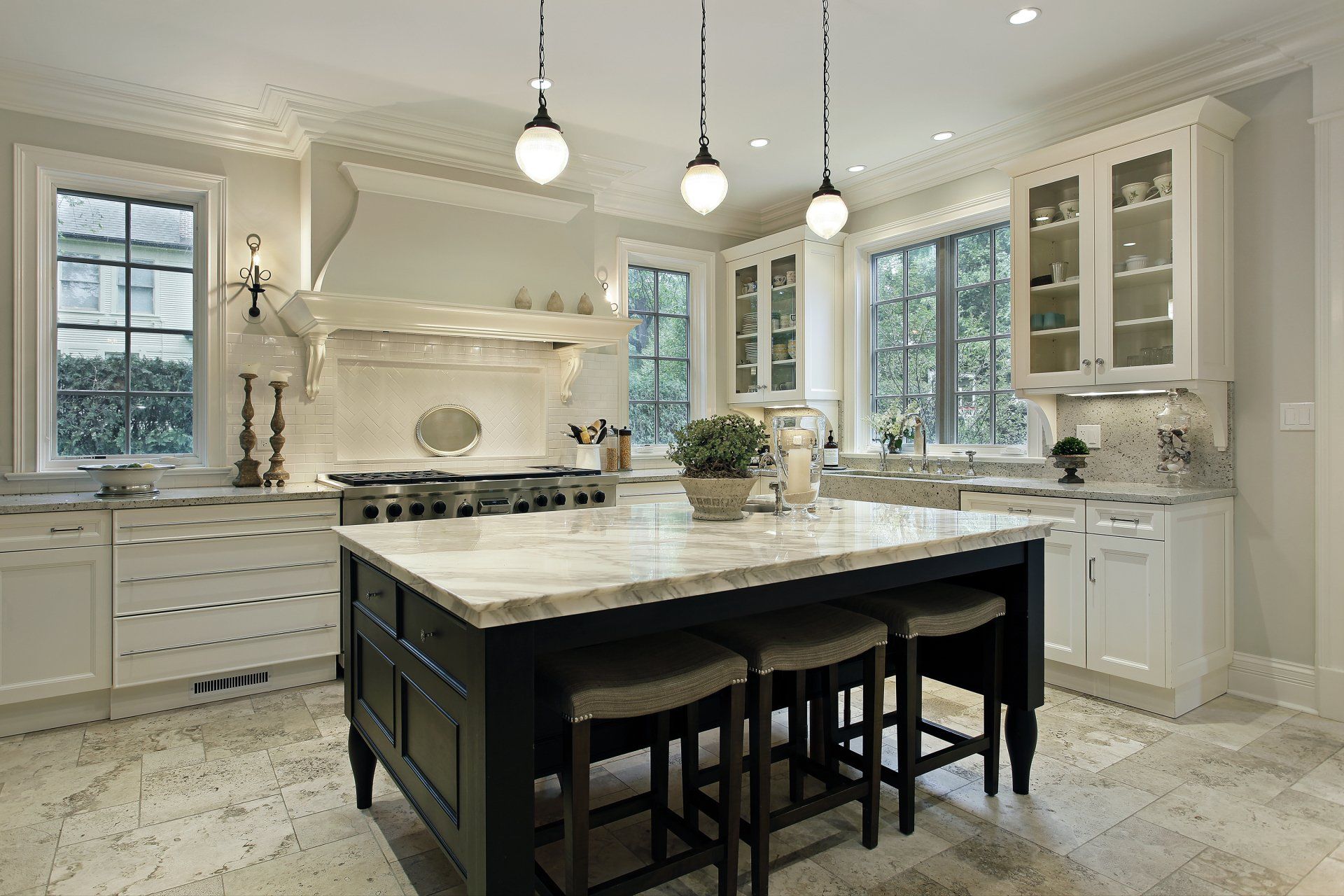 A kitchen with white cabinets and a large island in the middle.