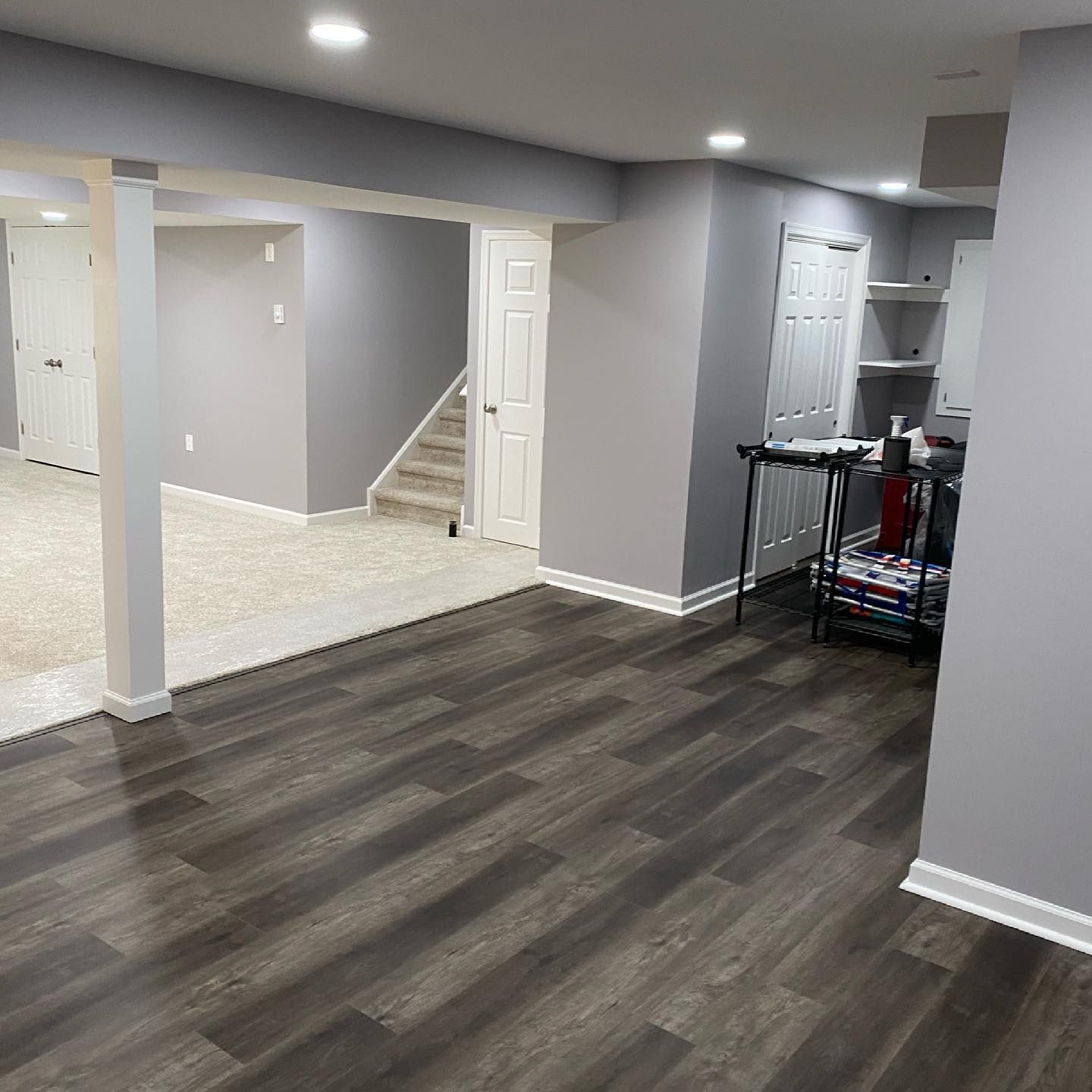 A basement with hardwood floors and gray walls.
