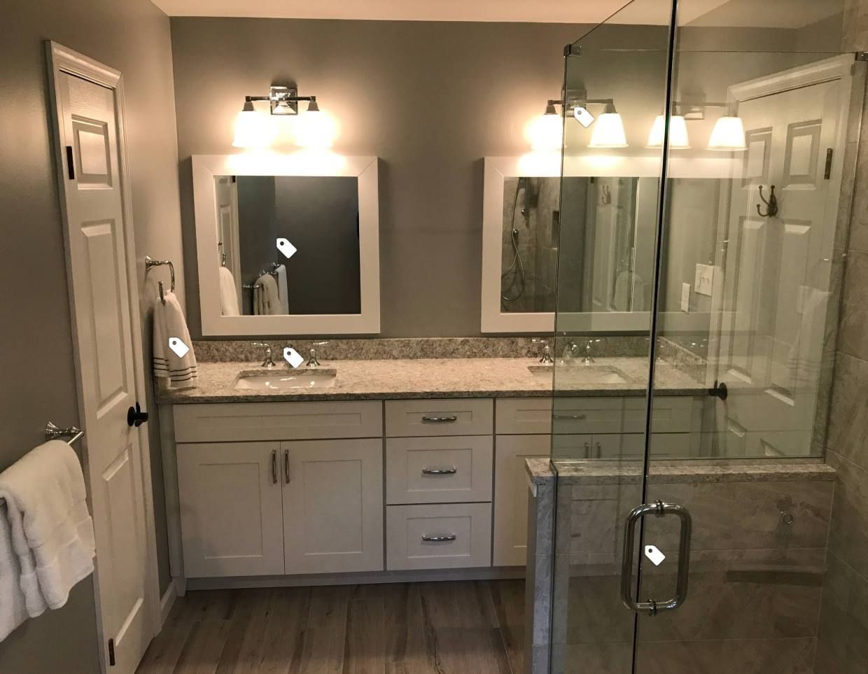 A bathroom with two sinks and a walk in shower.