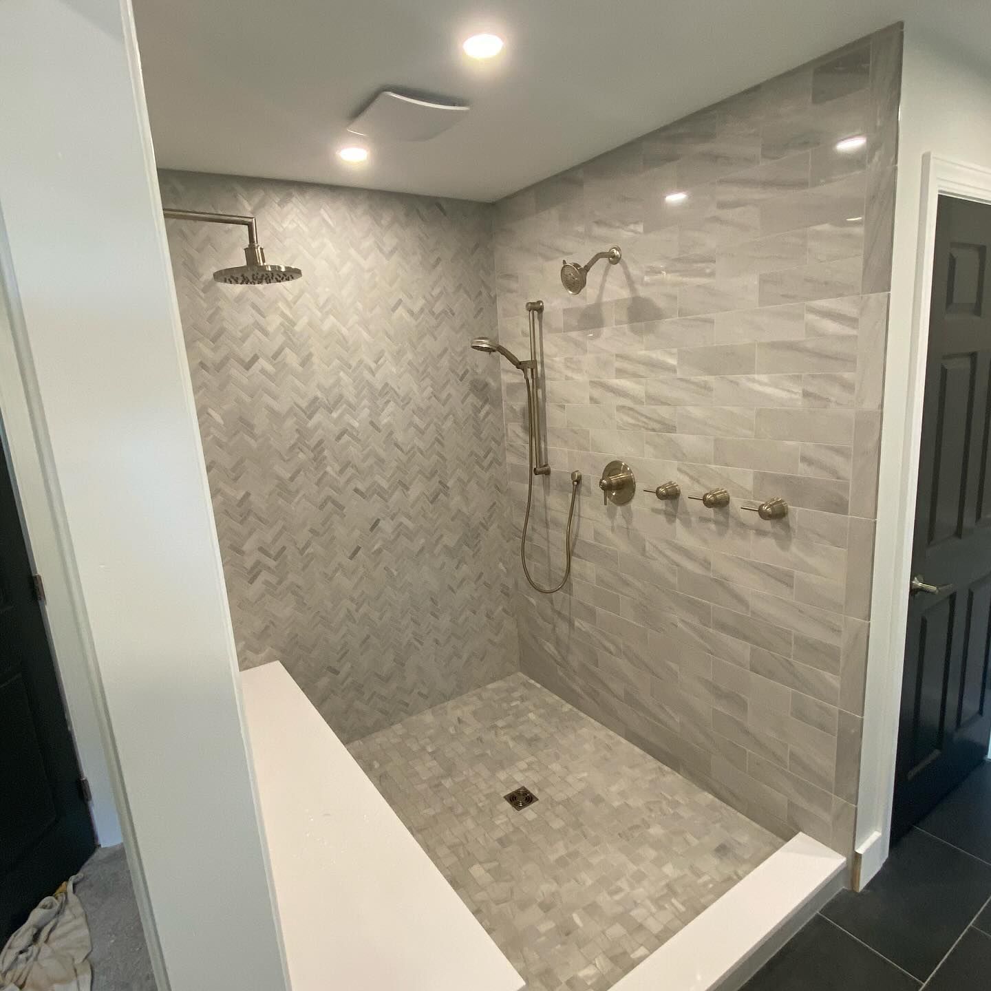 A bathroom with a walk in shower and a shower head.