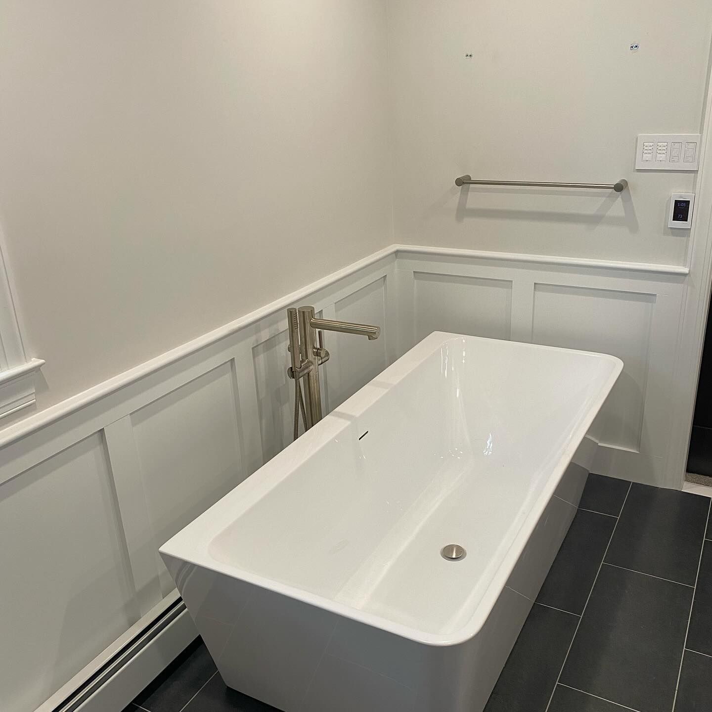 A white bathtub is sitting in a bathroom next to a wall.