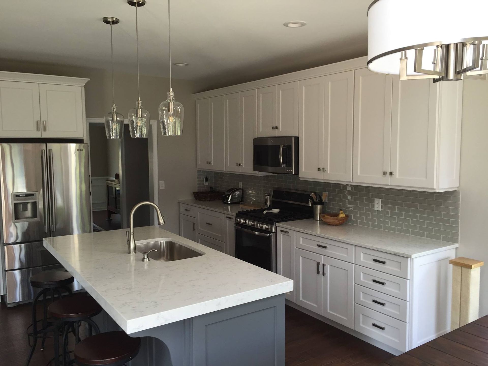 A kitchen with white cabinets and stainless steel appliances