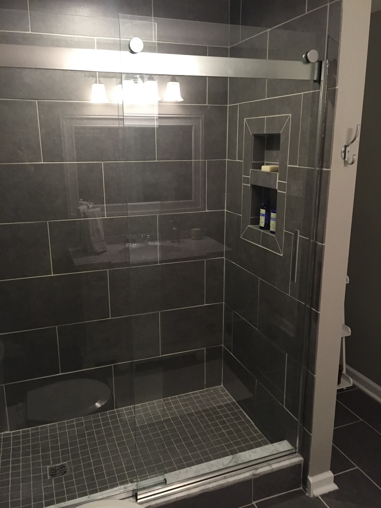 A bathroom with a sliding glass shower door