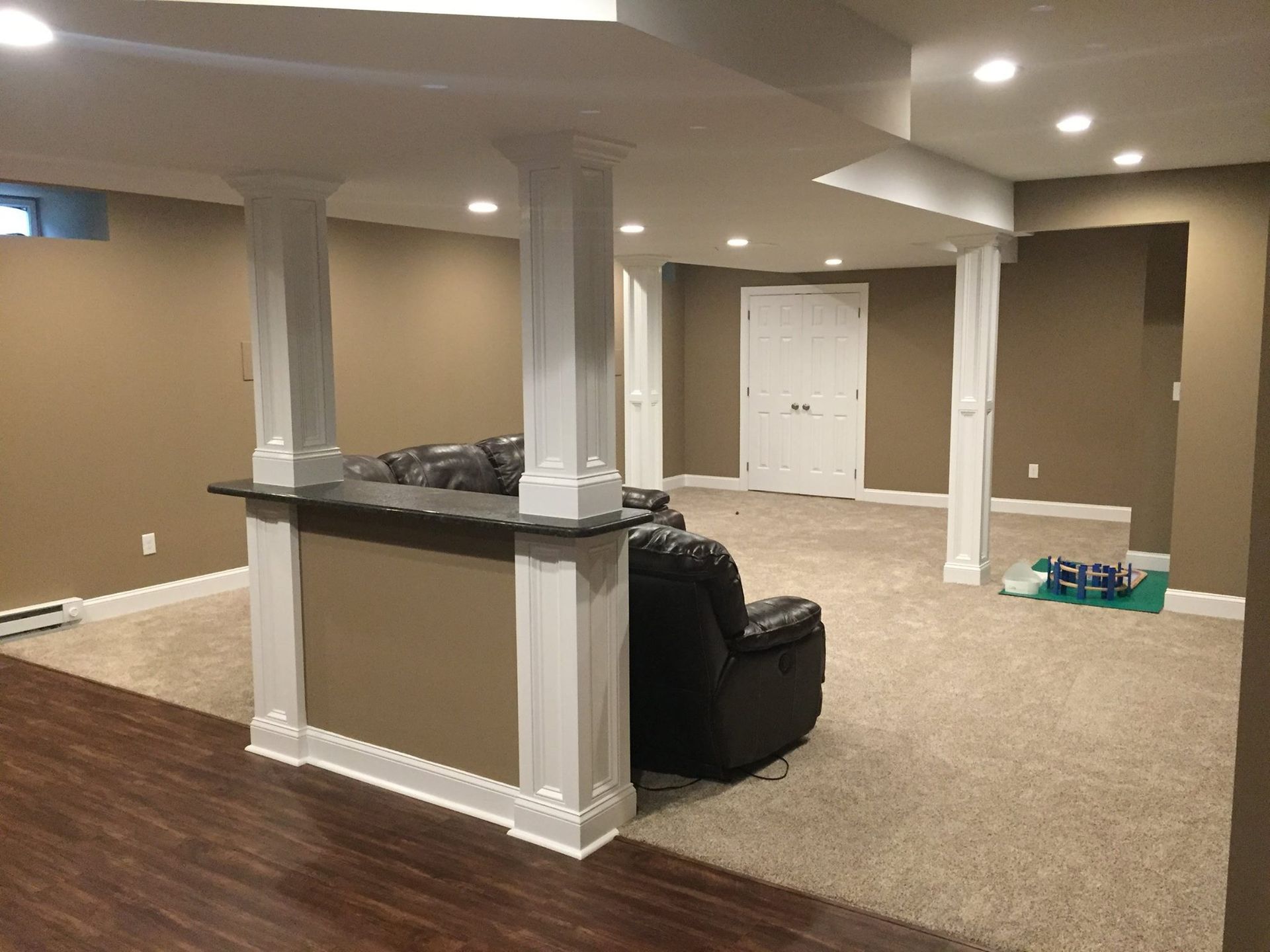 A basement with a couch and a bar in it.