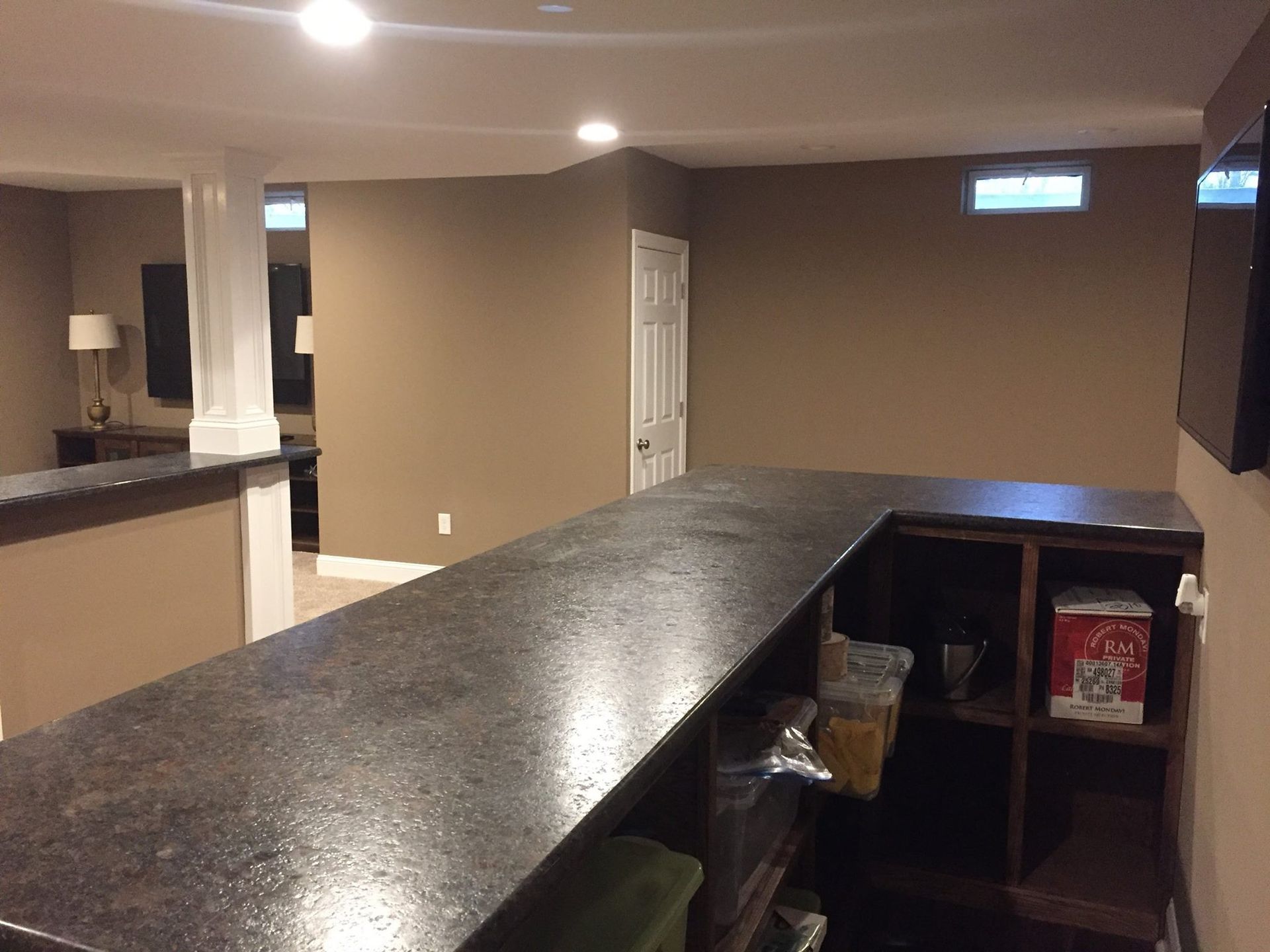 A bar in a basement with a tv on the wall.