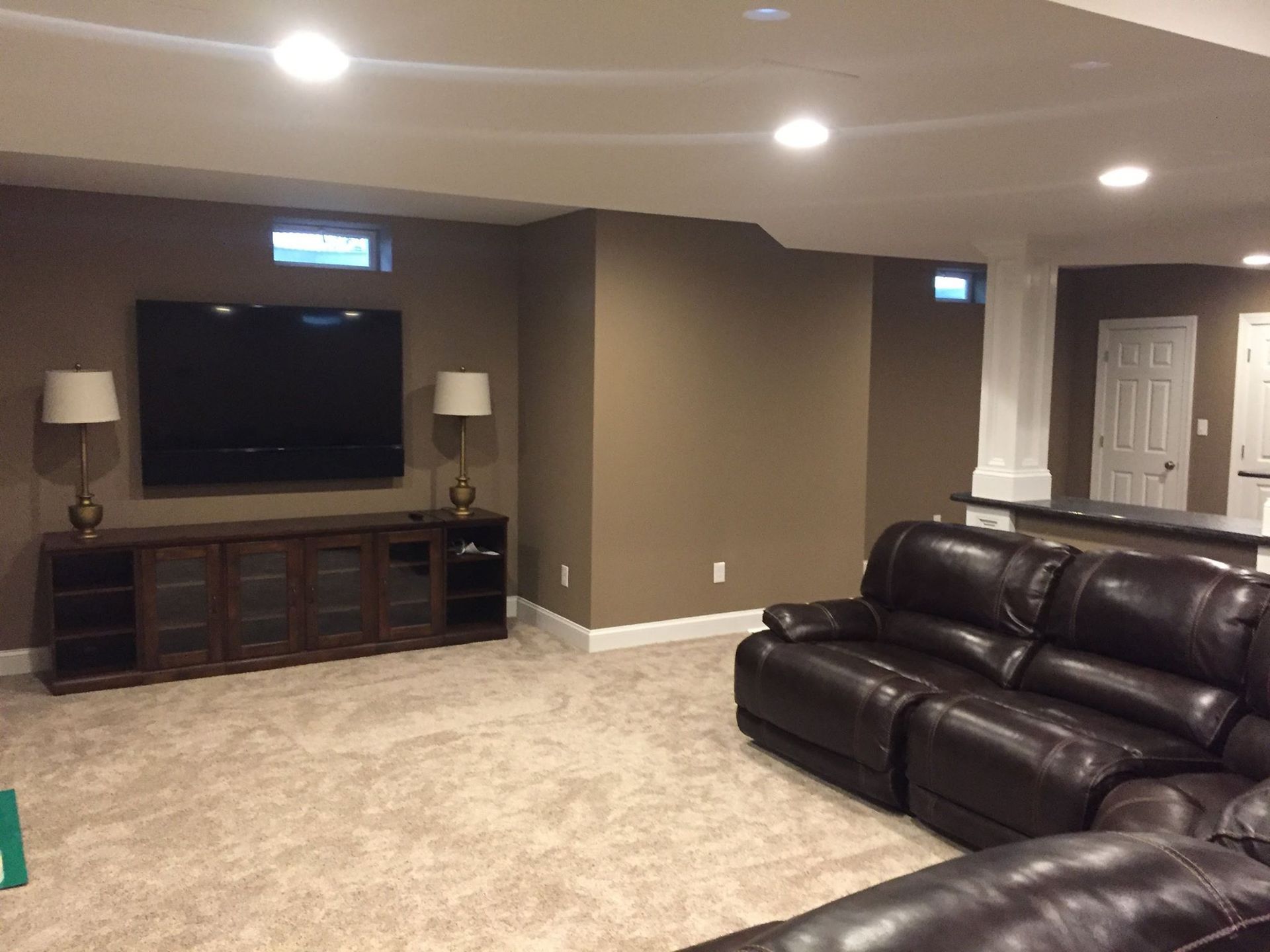 A living room with a couch and a flat screen tv on the wall.