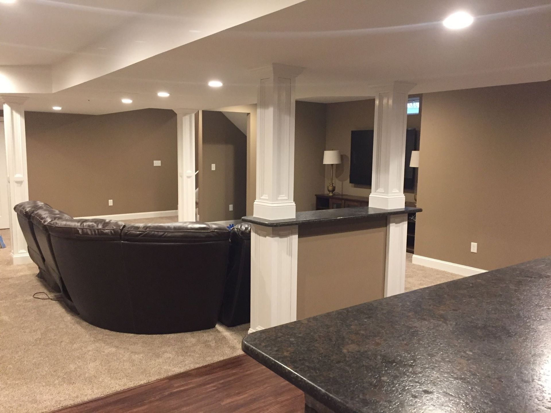A basement with a couch and a counter in it