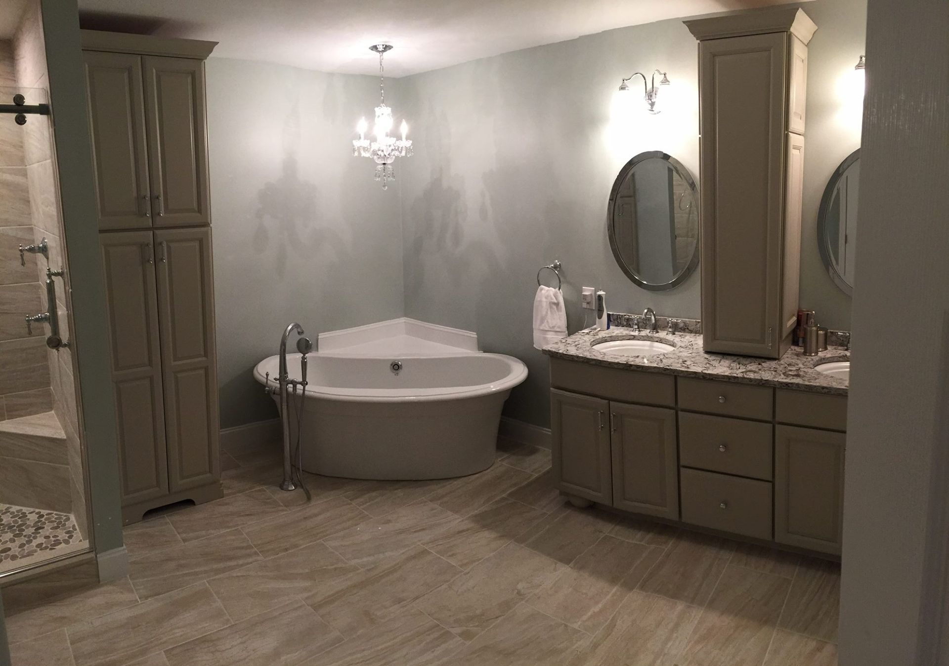 A bathroom with a tub , sinks , mirrors and cabinets.