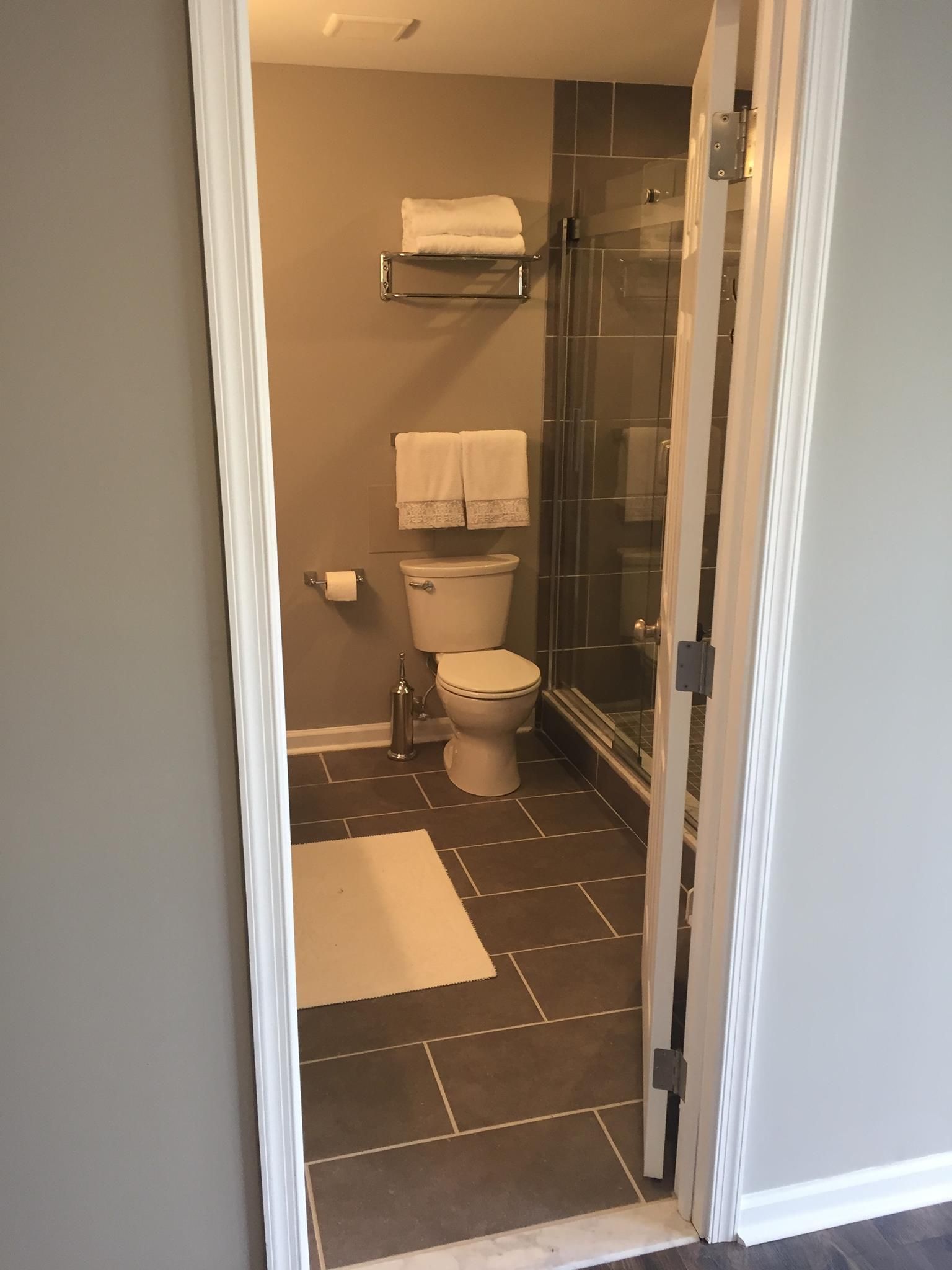 A bathroom with a toilet and a walk in shower