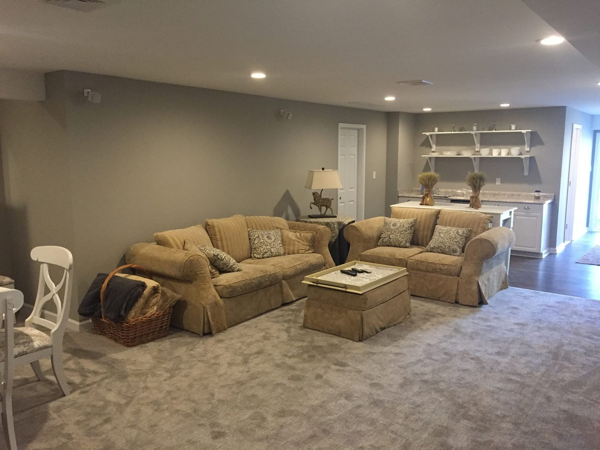 A living room with a couch , chair , coffee table and rug.