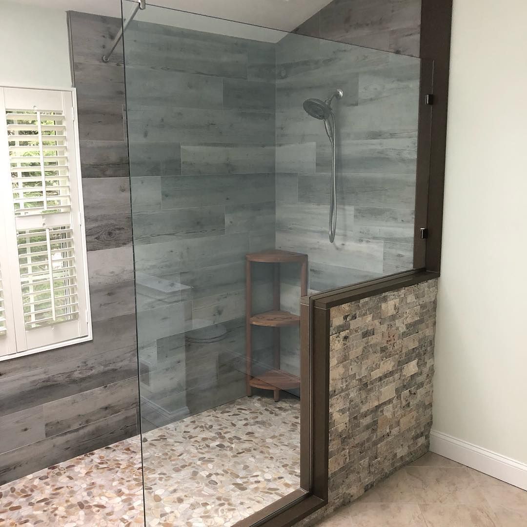 A bathroom with a walk in shower with a glass door.