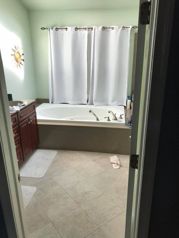 A bathroom with a bathtub and a shower curtain.