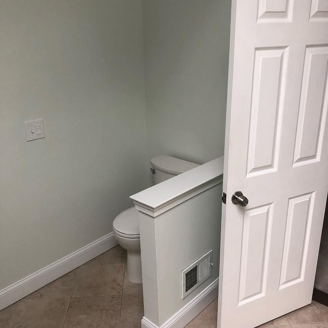 A bathroom with a toilet and a door that is open.