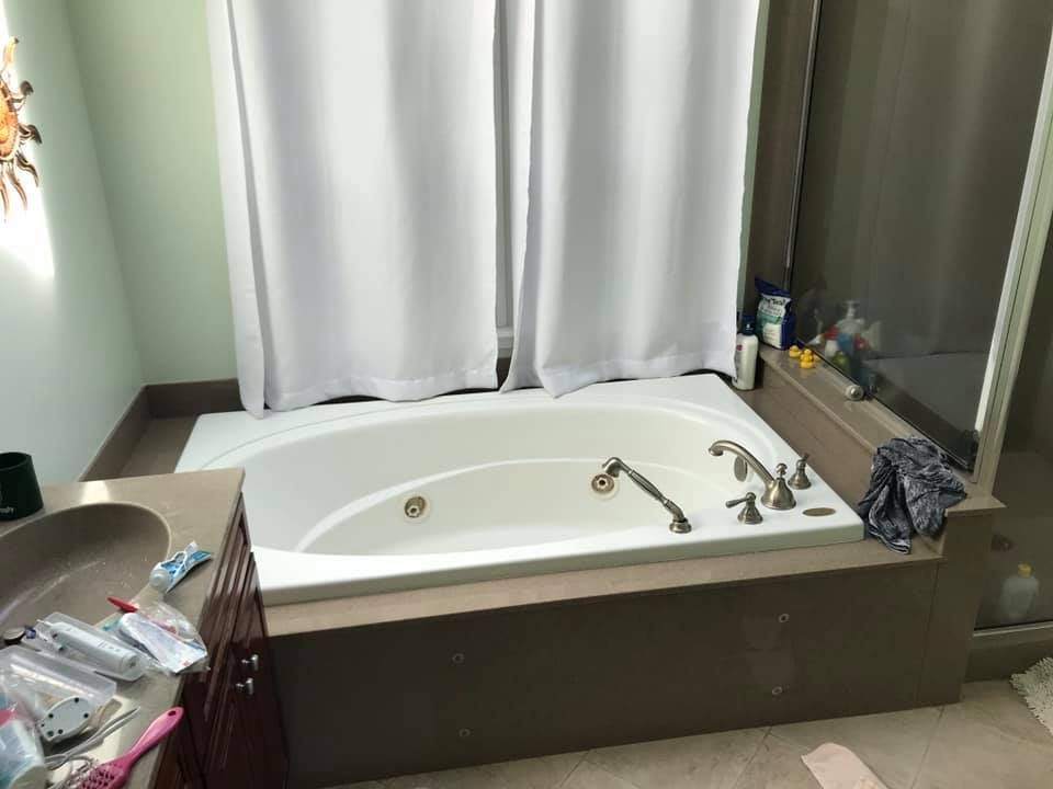 A bathroom with a jacuzzi tub and a shower curtain.