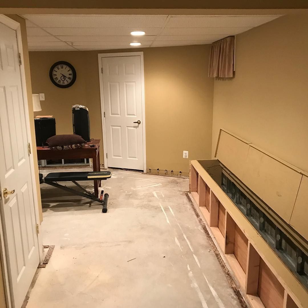 A room with a clock on the wall and a bench