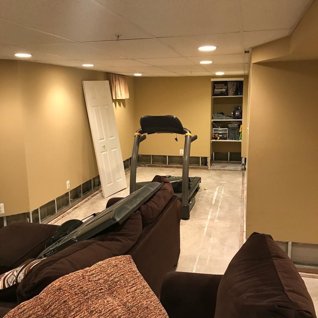 A living room with a treadmill and a couch