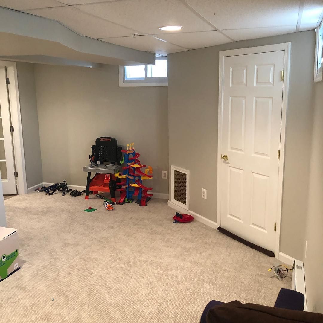 A basement with a lot of toys on the floor and a door.