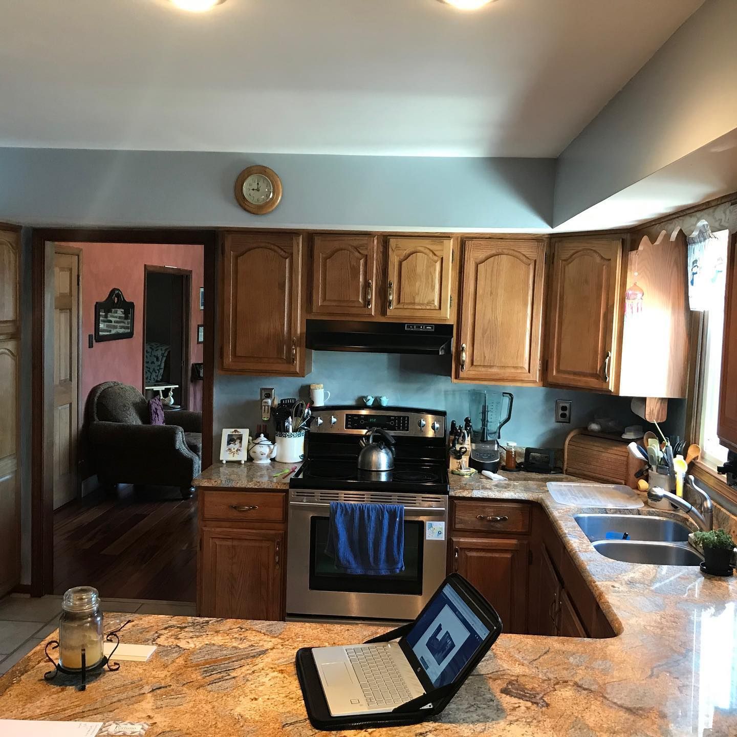 A kitchen with wooden cabinets and a laptop on the counter