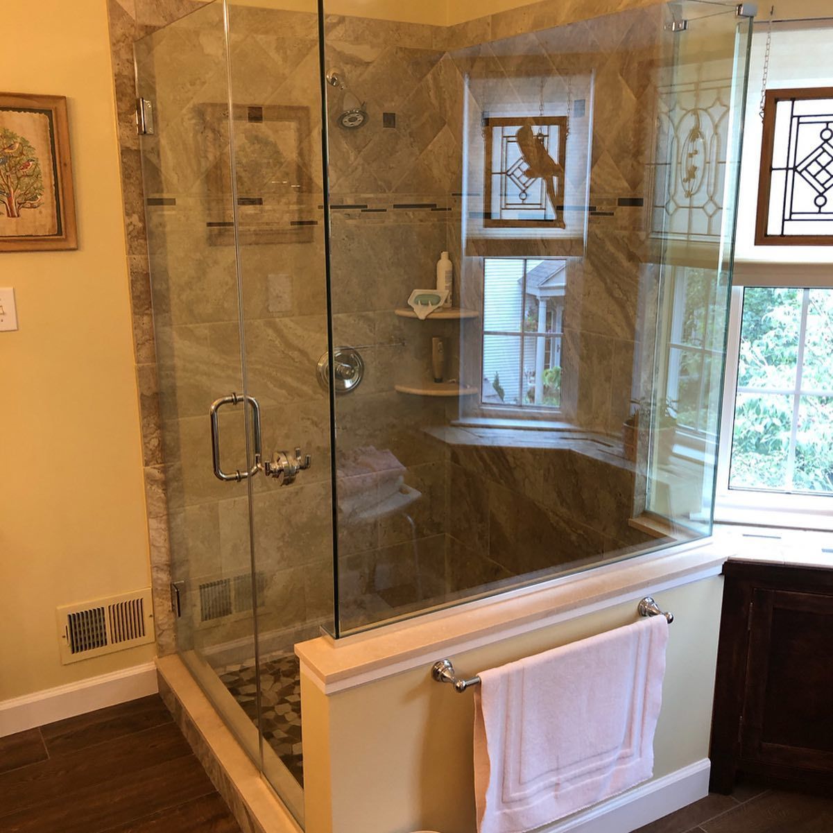 A bathroom with a walk in shower and a window