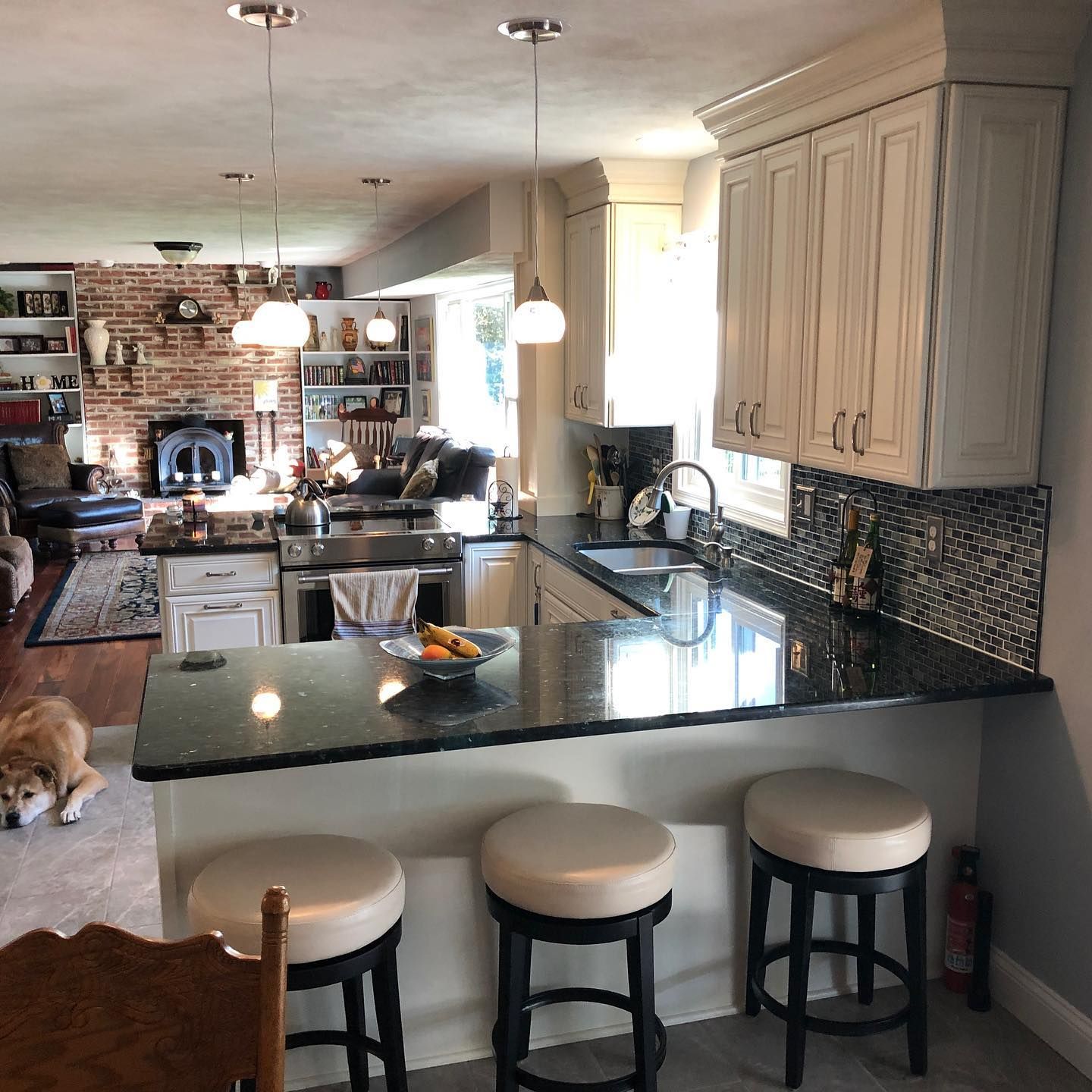 A kitchen with white cabinets and black counter tops