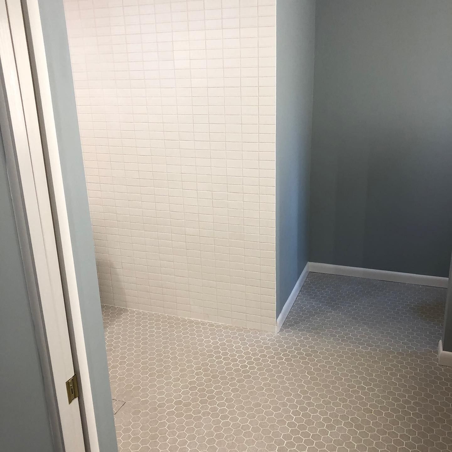 A bathroom with a walk in shower and a tiled floor.