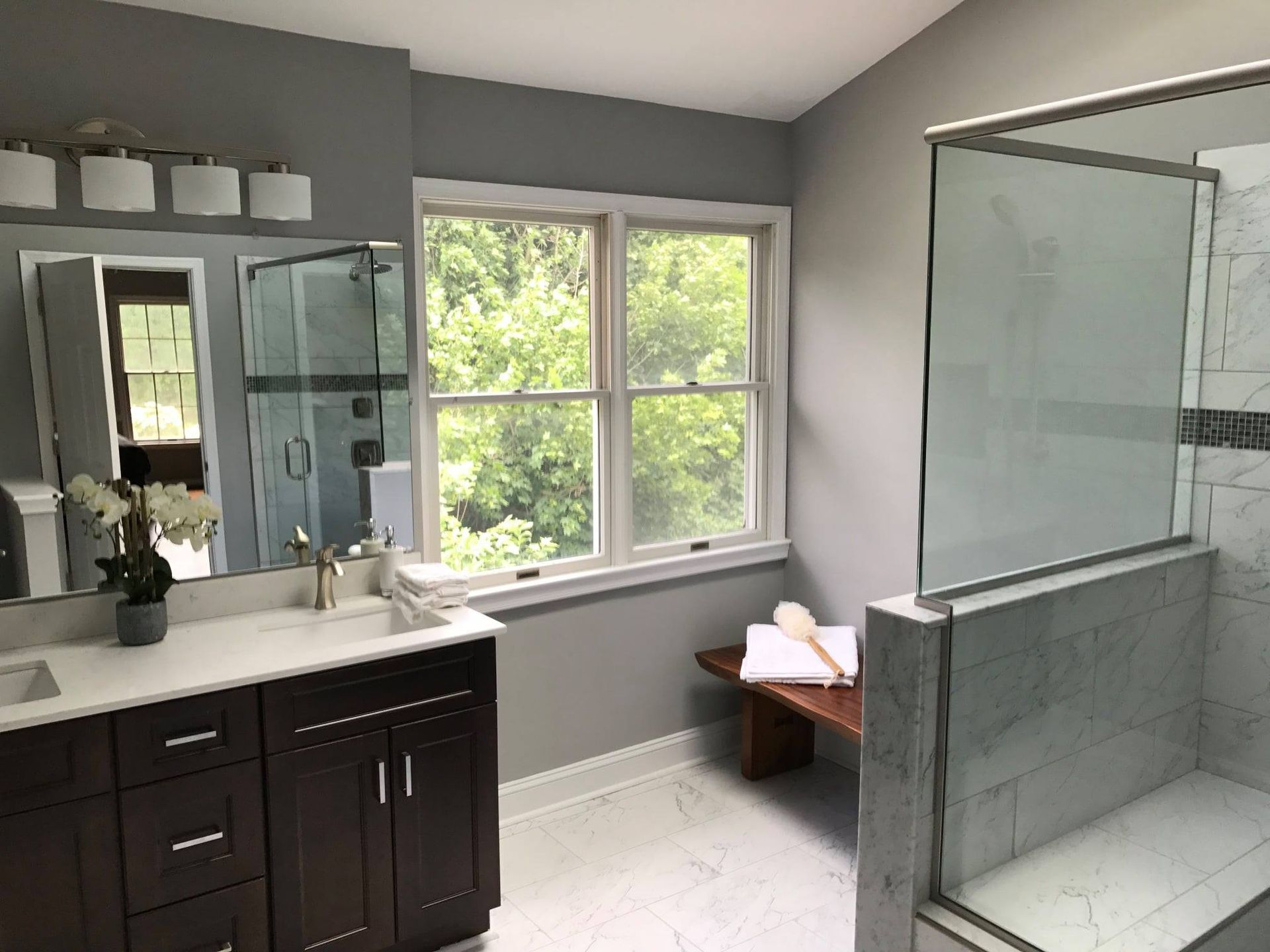 A bathroom with two sinks and a walk in shower.